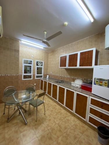 cocina con mesa y sillas en una habitación en ALJAWHARA INN HOTEL, en Seeb