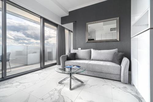 Una sala de estar con un sofá y una mesa de cristal. en Apartament w Hanza Tower, en Szczecin