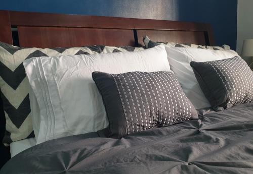 una cama con varias almohadas encima en LaraHome City Living, en Mandaue