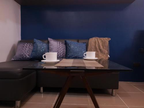 a coffee table with two cups on top of a couch at LaraHome City Living in Mandaue City