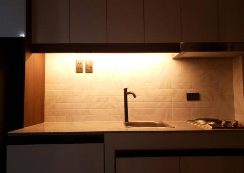 una cocina con fregadero y una luz en la pared en LaraHome City Living, en Mandaue