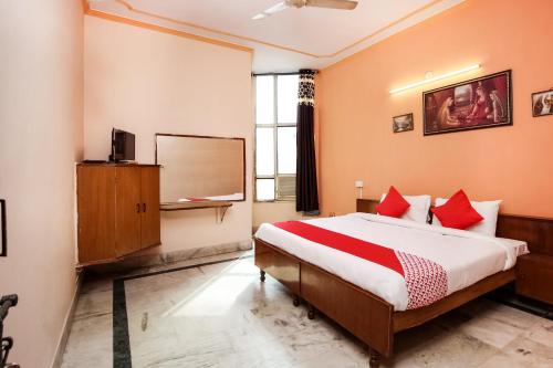 een slaapkamer met een groot bed met rode kussens bij Hotel Apoorva DLX in Jaipur