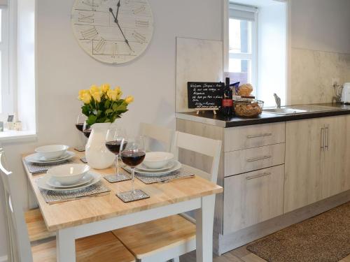 a kitchen with a table with glasses of wine at Hill Street Cottage in Portpatrick
