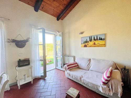 sala de estar con sofá blanco y ventana en Una casa in Val di Chiana - Tuscan Country House Cetona en Cetona