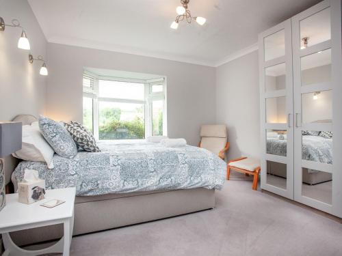 Habitación blanca con cama y ventana en Leighwood Cottage, en Paignton