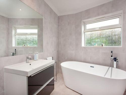 y baño con bañera blanca y lavamanos. en Leighwood Cottage, en Paignton