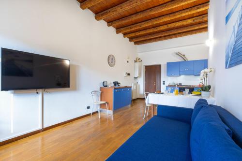 uma sala de estar com um sofá azul e uma televisão em Residenza al Corso em Verona