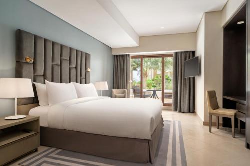a bedroom with a large bed and a desk at Wyndham Residences The Palm in Dubai