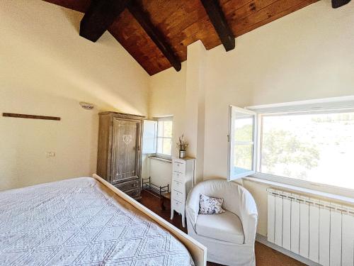sypialnia z łóżkiem, krzesłem i oknem w obiekcie Una casa in Val di Chiana - Tuscan Country House Cetona w mieście Cetona