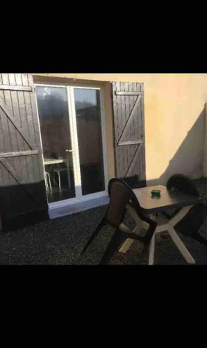 a chair and a table in a room with a window at Studio le cosy centre de gaillon(wifi) in Gaillon