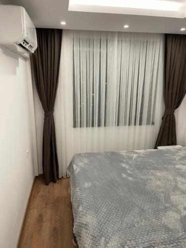 a bedroom with a bed and curtains and a television at ORION APARTMENTS in Chepelare