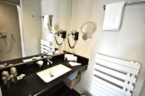 a bathroom with a sink and a phone at Hôtel de Provence in Cannes