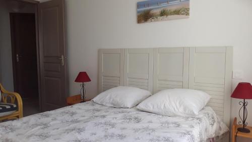 LʼHerbaudièreにあるMaison de vacances Ile de noirmoutierの白いベッドと枕が2つある寝室