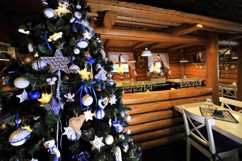 a christmas tree with ornaments on it in a restaurant at APLEND Koliba Kamzík in Smokovce
