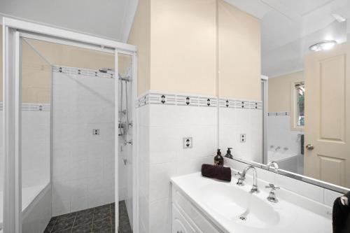 a white bathroom with a sink and a shower at Aqua Vista in Smiths Lake