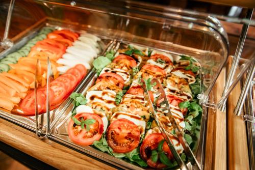 a tray of food with tomatoes and other foods at Ferienhotel Almajur in Mittelberg