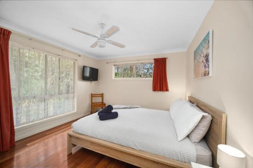 1 dormitorio con 1 cama y ventilador de techo en Aqua Vista, en Smiths Lake