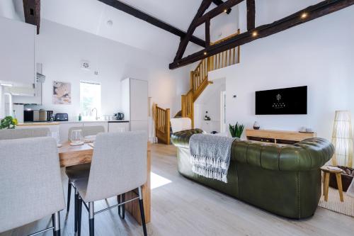 uma sala de estar com uma mesa e um sofá de couro verde em Wild Drive Chester - Stunning cottage in CH1 with Double Parking em Chester