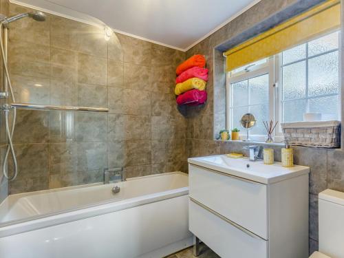 a bathroom with a tub and a sink and a shower at Riverside Cottage in Reedham