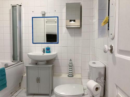 a white bathroom with a sink and a toilet at Ace Lodge in Hoddesdon