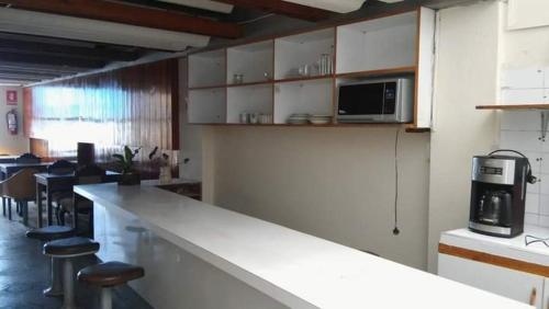 a kitchen with a counter with stools and a microwave at Hotel Estación Central in Lima