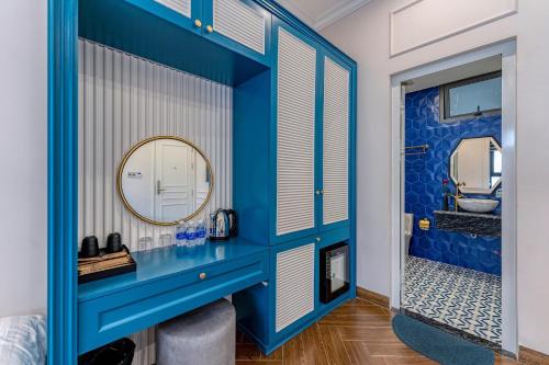 a bathroom with a blue wall and a mirror at Padona Hotel in Da Lat