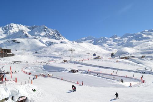 a group of people skiing down a snow covered slope at Résidence Montana Premier in Val Thorens