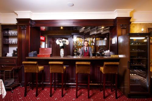 a bar in a restaurant with a man behind the counter at Boutique Hotel California in Odesa