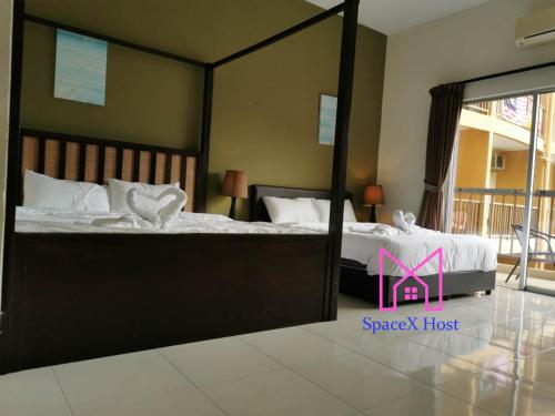 a bedroom with two beds and a large mirror at Gold Coast Morib Resort in Banting