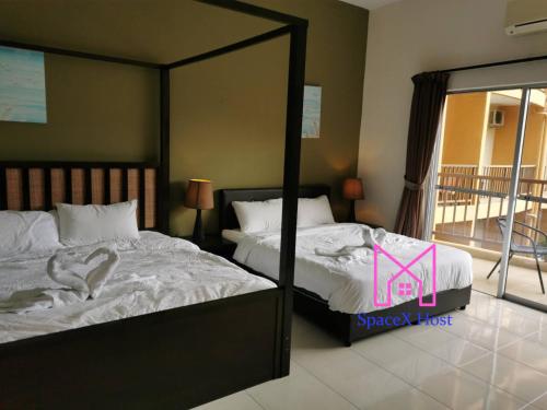 a bedroom with two beds and a mirror at Gold Coast Morib Resort in Banting