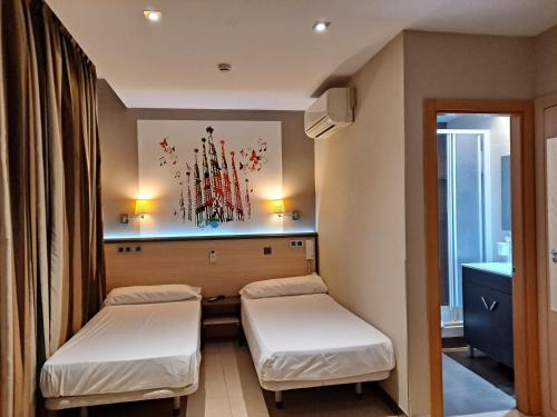 Cama o camas de una habitación en Hostal Las Flores Ramblas