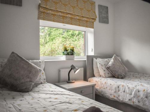 a bedroom with two beds and a window at Bumblebee Lodge in Staithes