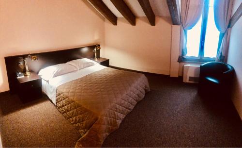 a hotel room with a bed and a window at MOTEL Malpensa INN & Hotel-Airport in Tornavento