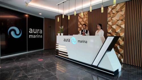 two people standing at a counter in a lobby at AURA MARINA HOTEL in Istanbul