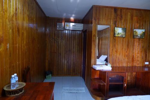 a wooden room with a table and a wooden wall at Song Lao Guesthouse in Thakhek