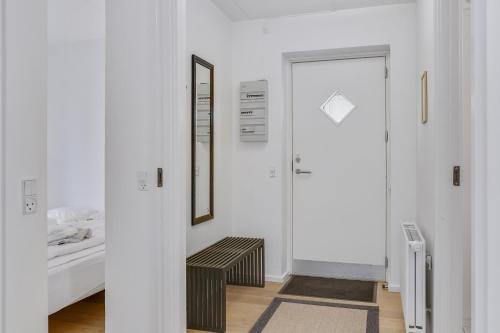 a white room with a bed and a mirror at Skagen Harbour Apartments in Skagen