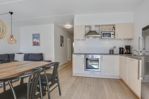 a kitchen and dining room with a table and chairs at Skagen Harbour Apartments in Skagen