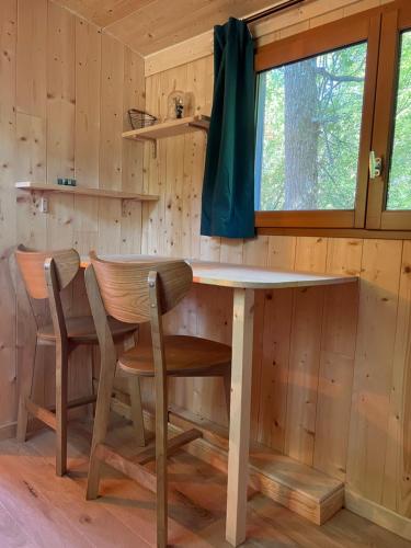 een eetkamer met een tafel en stoelen in een hut bij La Garenne Saint Germain in Saint-Germain-de-Marencennes