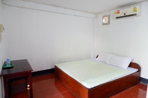 a small bedroom with a bed and a table at Song Lao Guesthouse in Thakhek