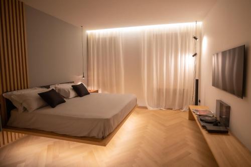 a bedroom with a bed and a window with white curtains at S1 Luxury Suites and Rooms in Trieste