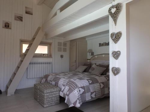 sypialnia z łóżkiem i schody z sercami na ścianie w obiekcie Gite les bois 1 w mieście Gignac