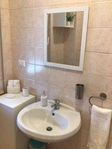 een badkamer met een wastafel en een spiegel bij Ostia Bed and Beach in Lido di Ostia