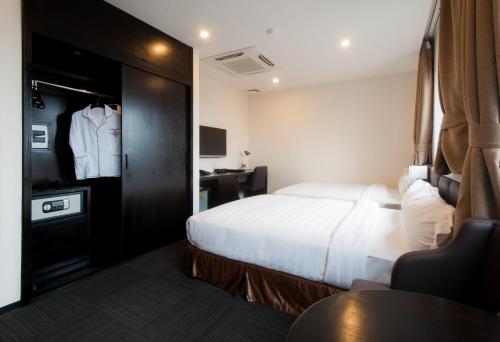 a hotel room with a bed and a dresser at Sakura Hotel in Hanoi