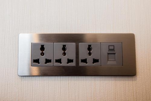 a metal switch with three lights on a wall at Sakura Hotel in Hanoi