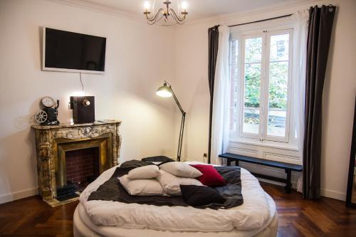 ein Schlafzimmer mit einem Bett mit Kissen und einem Kamin in der Unterkunft Félix dOrt in Lyon