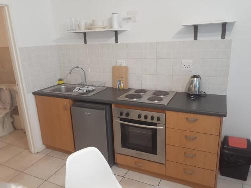 a kitchen with a stove and a sink at Durham Square Apartments in Cape Town