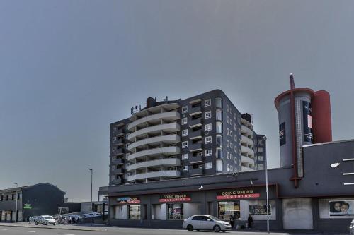 ein hohes Gebäude mit einem davor geparkt in der Unterkunft Durham Square Apartments in Kapstadt