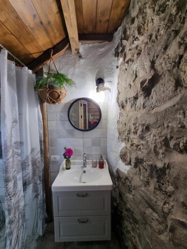 a bathroom with a sink and a stone wall at El Nido Fuente Hervera. Precioso Loft con Bañera de Hidromasaje in Vega de San Mateo