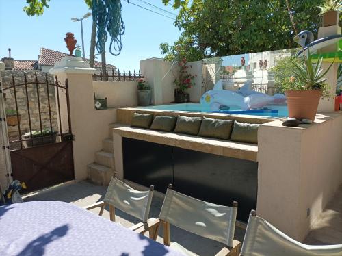 un patio trasero con piscina, mesa y sillas en La Casa De La Ciotat en La Ciotat