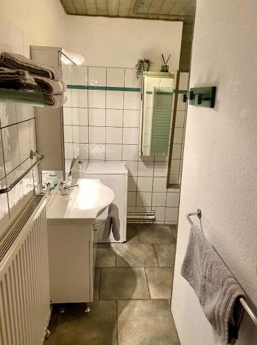 une salle de bain blanche avec un lavabo et un miroir dans l'établissement L’Alsacien Cosy : Duplex - Netflix - Wifi/Fibre, à Mulhouse